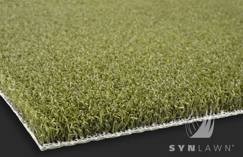 Macro view of green artificial grass blades with brown thatch for a natural lawn appearance.
